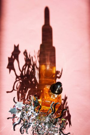 Serum kosmetische Pipettenflasche wirft Schatten auf rosa Oberfläche. Silbernes Lametta, festliches Dekor. Beauty-Produkte. Neujahr Geschenk qualitativ hochwertige Foto.