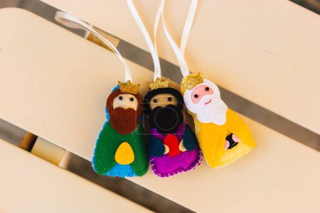 Christmas composition of three wise men Melchior, Caspar, Balthazar on yellow background. Epiphany Day or Dia de tres Reyes Magos. Traditional Three kings day decor, bright toys. Happy Epiiphany day.