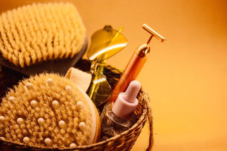 Hard-bristled massage brushes. Body skin care tools. Beauty products. Still life with women's cosmetics, electrical facial massager, sunglasses.