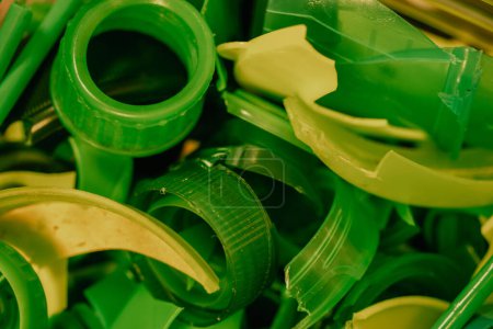 Foto de Reciclaje de tapas de botellas de plástico verde para ser reutilizados para la fabricación. Nueva vida al viejo concepto de basura. Trituradora de plástico Proceso de reutilización. - Imagen libre de derechos