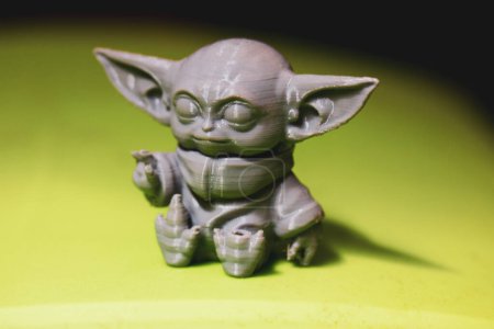 Photo for Madrid, Spain 7 May 2024 Din Grogu, Star wars toy hero made of recycling plastic isolated on green background. Happy baby Yoda from Disney series. - Royalty Free Image