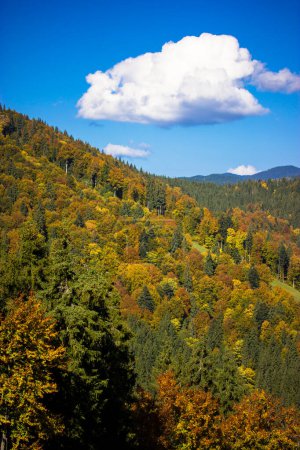 Große weiße Wolken am blauen Himmel, Berglandschaft an einem sonnigen Herbsttag. Berge, Hügel im Herbst. Vertikale Aufnahme des Naturschutzgebietes. 