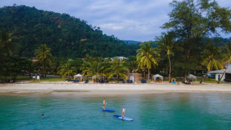 Photo for A couple of men and women paddled at a sup board at a tropical Island in Koh Chang Thailand. stand-up paddleboard - Royalty Free Image