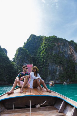 Foto de Mujeres tailandesas y hombres caucásicos frente a un bote de cola larga en la laguna de Koh Phi Phi Tailandia. Laguna de Pileh Tailandia Koh Phi Phi - Imagen libre de derechos