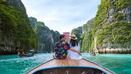 Photo for Thai women and Caucasian men in front of a Longtail boat at the lagoon of Koh Phi Phi Thailand. Pileh Lagoon Thailand Koh Phi Phi - Royalty Free Image