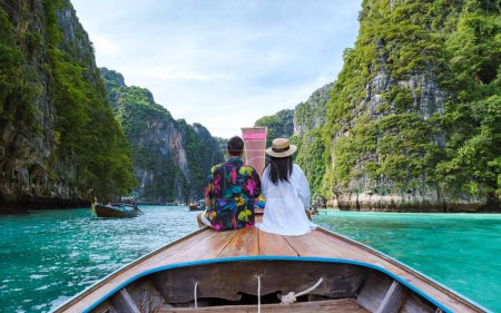 Foto de Pareja de hombres y mujeres frente al barco Longtail en la laguna de Koh Phi Phi Tailandia. Laguna de Pileh Tailandia Koh Phi Phi - Imagen libre de derechos