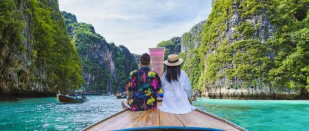 Téléchargez les photos : Couple d'hommes et de femmes devant le bateau Longtail au lagon de Koh Phi Phi Thaïlande. Lagune de Pileh Thaïlande Koh Phi Phi - en image libre de droit