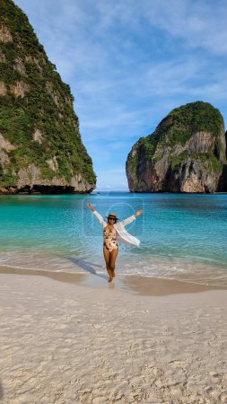 Photo for Thai Asian women walk on the beach with a hat at Maya Bay Koh Phi Phi Thailand. - Royalty Free Image