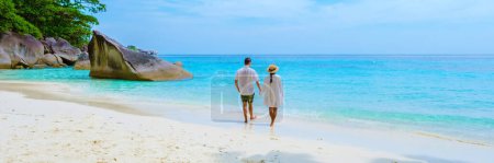 Photo for Caucasian men and Thai Asian women on the tropical white beach with turqouse colored ocean of Similan Islands Thailand. - Royalty Free Image