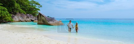 Photo for Caucasian men and Thai Asian women on the tropical white beach with turqouse colored ocean of Similan Islands Thailand. - Royalty Free Image