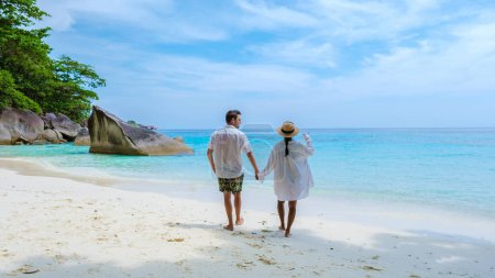 Photo for A couple of men and women on the tropical white beach with turqouse colored ocean of Similan Islands Thailand. - Royalty Free Image