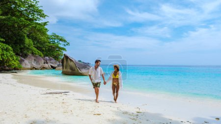 Téléchargez les photos : Hommes caucasiens et femmes asiatiques thaïlandaises sur la plage de sable blanc tropical avec turqouse couleur océan des îles Similan Thaïlande. - en image libre de droit