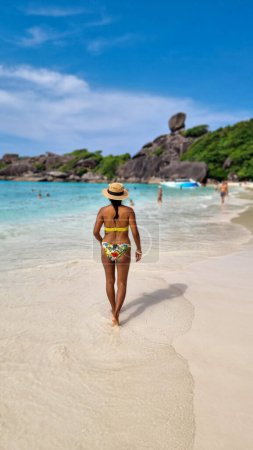 Téléchargez les photos : Femmes asiatiques allongées sur la plage de sable blanc tropical avec turqouse couleur océan des îles Similan Thaïlande. - en image libre de droit