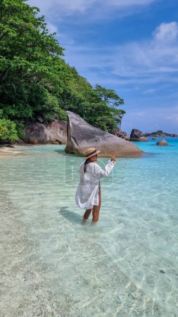 Photo for Asian women laying down on the tropical white beach with turqouse colored ocean of Similan Islands Thailand. - Royalty Free Image