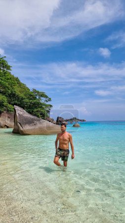 Téléchargez les photos : Jeunes hommes en short de bain sur la plage des îles Similan en Thaïlande. - en image libre de droit