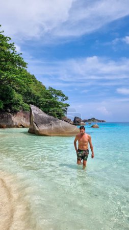 Téléchargez les photos : Jeunes hommes caucasiens en short de bain sur la plage des îles Similan en Thaïlande. - en image libre de droit