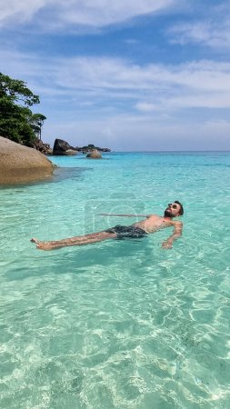 Téléchargez les photos : Jeunes hommes caucasiens en short de bain sur la plage des îles Similan en Thaïlande. - en image libre de droit