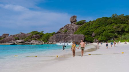 Foto de Un par de hombres blancos y mujeres asiáticas en un viaje a la isla tropical con playa blanca Islas Similan Tailandia. - Imagen libre de derechos