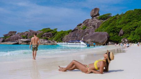 Téléchargez les photos : Hommes et femmes sur une plage de sable blanc tropicale dans les îles Similan Thaïlande. - en image libre de droit