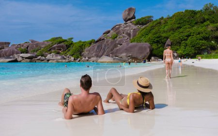 Foto de Un par de hombres caucásicos y mujeres tailandesas en un viaje a la isla tropical con playa blanca Similan Islands Tailandia. - Imagen libre de derechos