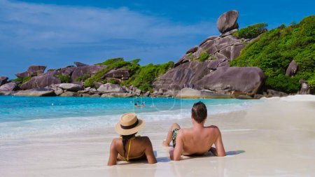 Téléchargez les photos : Des hommes et des femmes bronzer sur une plage de sable blanc sur une île tropicale pendant une lune de miel - en image libre de droit