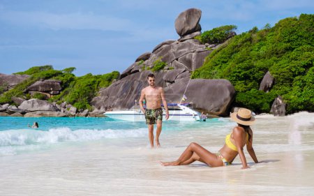 Téléchargez les photos : Hommes caucasiens et femmes noires se détendent sur une plage tropicale en Thaïlande, les îles Similan. - en image libre de droit