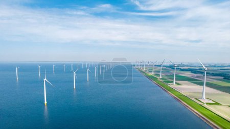 Photo for Windmill turbines at sea view from a drone aerial view from above at a huge windmill park in the Netherlands. - Royalty Free Image