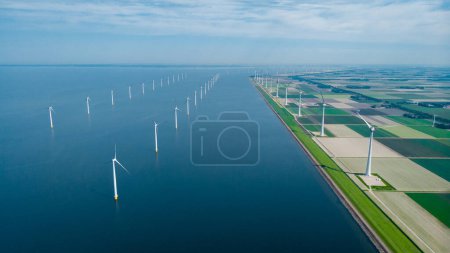Foto de Turbinas de molino de viento en vista al mar desde una vista aérea de drones desde arriba en un enorme parque de molinos de viento - Imagen libre de derechos
