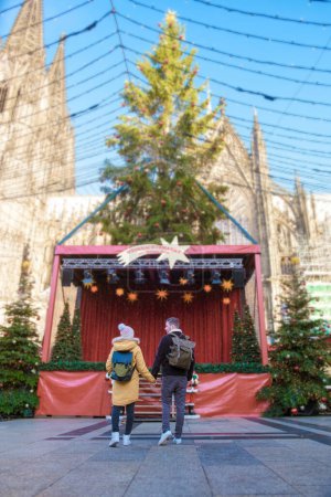 Téléchargez les photos : Un couple d'hommes et de femmes visitant un marché de Noël à Cologne, Un couple en voyage en ville à Cologne en Allemagne pendant l'hiver en Europe. - en image libre de droit