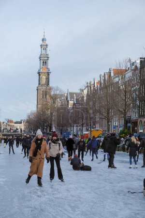 Photo for Amsterdam Netherlands February 2021, a cold winter day with people ice skating at the frozen canals in winter. - Royalty Free Image
