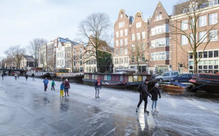 Foto de Ámsterdam Países Bajos febrero 2021, un frío día de invierno con gente patinando en los canales congelados en invierno. - Imagen libre de derechos