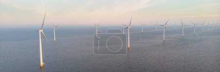 Photo for Drone aerial view at Windmill turbines at sea with a blue sky - Royalty Free Image
