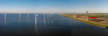 Foto de Turbinas de molino de viento en el mar con un cielo azul Vista aérea de Drone en un parque de molinos de viento en los Países Bajos - Imagen libre de derechos