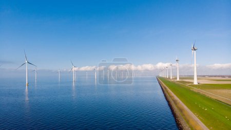 Foto de Turbinas de molinos de viento en el mar con un cielo azul visto desde el cielo con un dron - Imagen libre de derechos