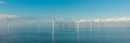 Foto de Turbinas de molino de viento en el mar con un cielo azul Vista aérea de Drone en un parque de molinos de viento en los Países Bajos - Imagen libre de derechos