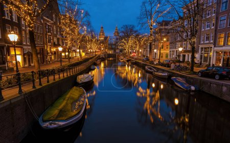Foto de Amsterdam Países Bajos canales con luces de Navidad durante la noche de diciembre, canal centro histórico de Amsterdam por la noche. - Imagen libre de derechos