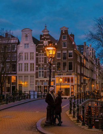 Téléchargez les photos : Amsterdam Pays-Bas canaux avec lumières de Noël en Décembre, un couple en voyage en ville pendant l'hiver - en image libre de droit