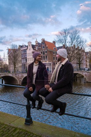 Photo for Amsterdam Netherlands canals with Christmas lights during December, a couple on a city trip during winter - Royalty Free Image