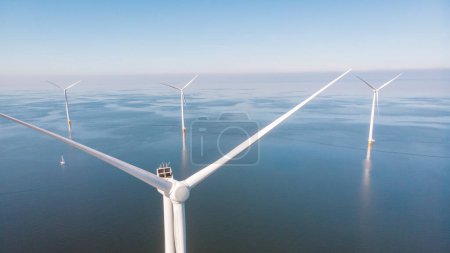 Foto de Turbinas de molino de viento en el mar con un concepto de energía verde cielo azul, vista aérea de drones en el parque de molinos de viento - Imagen libre de derechos