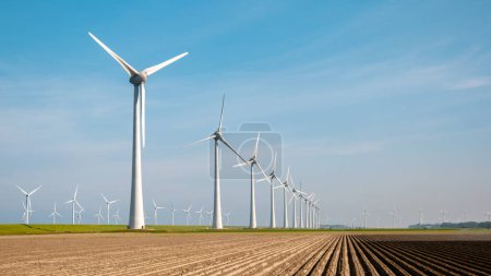 Photo for Wind mill park with Windmill turbines generating electricity with a blue sky green energy concept. Flevoland Netherlands - Royalty Free Image