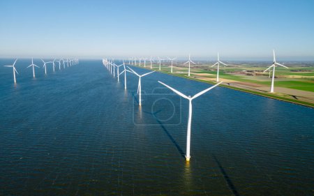 Téléchargez les photos : Parc éolien avec éoliennes générant de l'électricité avec un concept d'énergie verte ciel bleu - en image libre de droit