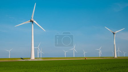 Photo for Windmill turbines generating electric with a blue sky green energy concept - Royalty Free Image