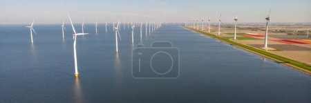 Photo for Windmill turbines at sea with a blue sky green energy concept - Royalty Free Image