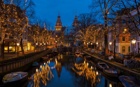 Photo for Amsterdam Netherlands canals with Christmas lights during December, Winter evening at the canal historical center of Amsterdam at night. - Royalty Free Image