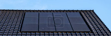 Foto de Casas de nueva construcción con paneles solares unidos al techo contra un cielo azul soleado en los Países Bajos - Imagen libre de derechos