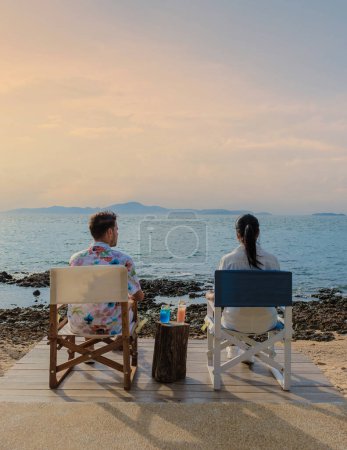 Téléchargez les photos : Couple déjeuner dans un restaurant donnant sur l'océan de Pattaya Thaïlande, homme et femme dîner dans un restaurant au bord de l'océan à Pattaya au coucher du soleil - en image libre de droit