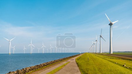 Foto de Las turbinas de molino de viento generan electricidad con un concepto de energía verde cielo azul, parque de molinos de viento en los Países Bajos Flevoland Ijsselmeer - Imagen libre de derechos