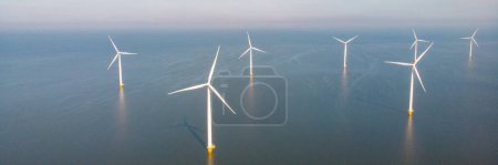 Foto de Vista aérea de aviones no tripulados en el molino de viento en las turbinas oceánicas que generan electricidad con un concepto de energía verde del cielo azul - Imagen libre de derechos