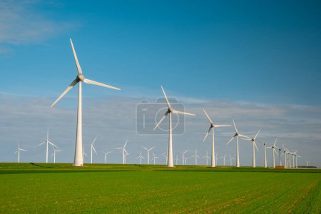 Téléchargez les photos : Moulin à vent par rapport aux éoliennes générant de l'électricité avec un concept d'énergie verte ciel bleu - en image libre de droit