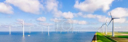 Téléchargez les photos : Éoliennes turbines pendant l'hiver générant de l'électricité avec un ciel bleu et des nuages - en image libre de droit